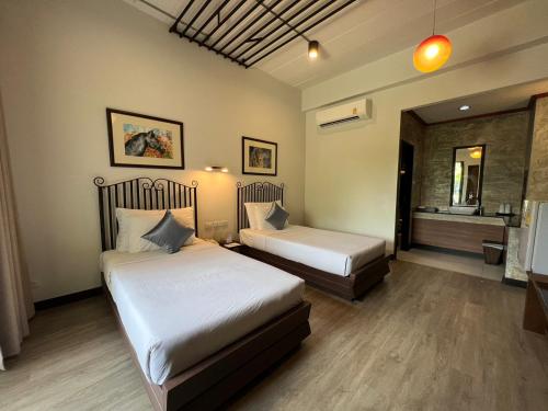 une chambre d'hôtel avec deux lits et une salle de bain dans l'établissement Horizon Village & Resort, à Doi Saket