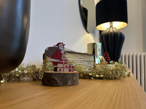 eine Weihnachtsmannfigur auf einem Tisch in der Unterkunft LE PALAIS DE LEO Luxury Apt Epernay Hyper center 4P Balcony AC in Épernay