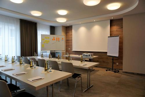 ein Klassenzimmer mit Tischen und Stühlen und einem weißen Bildschirm in der Unterkunft HeiMaT Häusle - Heike Marcus Tiny-houses in Cleebronn