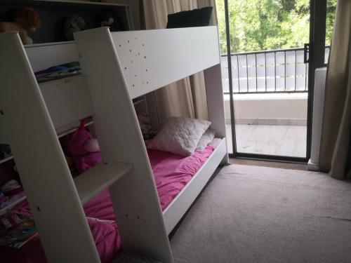 a childs bunk bed in a room with a window at Duplex in Tableview in Cape Town
