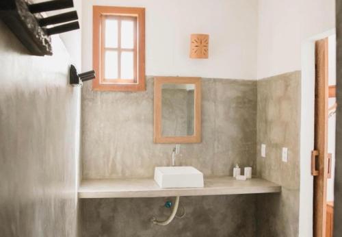 a bathroom with a sink and a mirror at Canto do Mar Caraiva in Caraíva