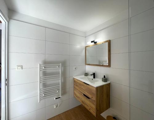 ein Badezimmer mit Waschbecken und Spiegel in der Unterkunft Charmant Duplex à la campagne in Riventosa