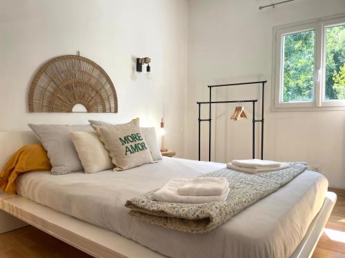 ein Schlafzimmer mit einem großen weißen Bett und Kissen in der Unterkunft Charmant Duplex à la campagne in Riventosa