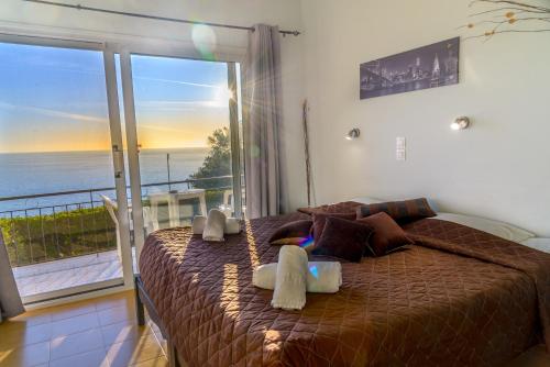 a bedroom with a bed with a view of the ocean at Sunny views studios in Agios Gordios