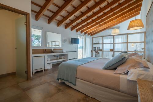 a bedroom with a bed and a desk and a sink at Agroturismo Son Vives Menorca - Adults Only in Ferreries