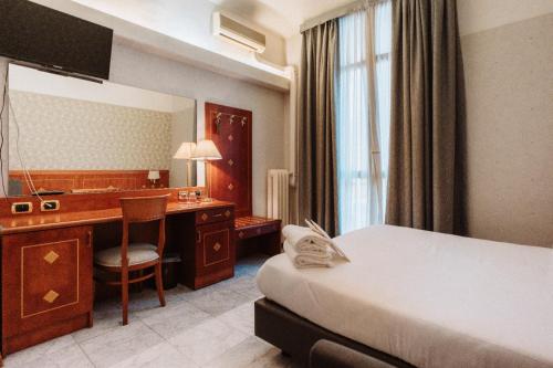Habitación de hotel con 1 dormitorio con escritorio y 1 cama en Hotel Chelsea, en Turín