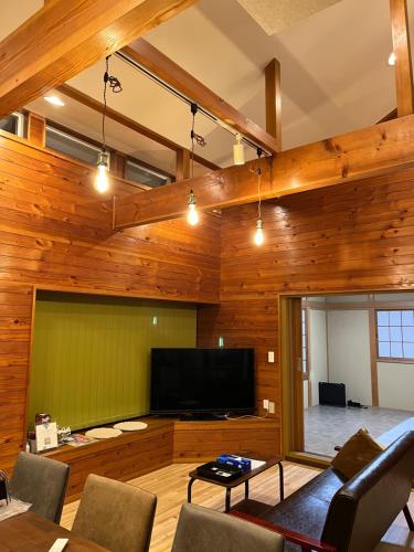 a living room with wooden walls and a flat screen tv at コテージ33 in Nasu