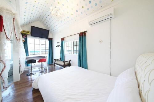 ein Schlafzimmer mit einem Bett und einem Schreibtisch in einem Zimmer in der Unterkunft Gangneung Maison de Rose in Gangneung