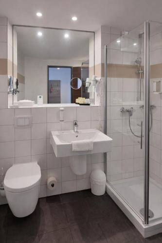 a bathroom with a sink and a toilet and a shower at Euro Hotel Friedberg in Friedberg