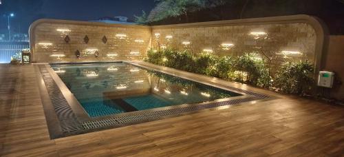 a swimming pool in a backyard at night at Sangath Banquet & Resort in Nadiad