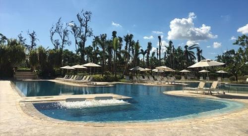 ein Swimmingpool mit Liegestühlen und Sonnenschirmen in einem Ferienresort in der Unterkunft Villa Jasmine Ritz Reserve Plantation residence in Higuillar