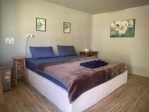a bedroom with a large bed with blue pillows at Ozone Beach House in Ko Lanta
