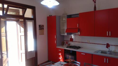 サンジネートにあるB&B Marinellaの赤いキャビネットと窓付きのキッチン