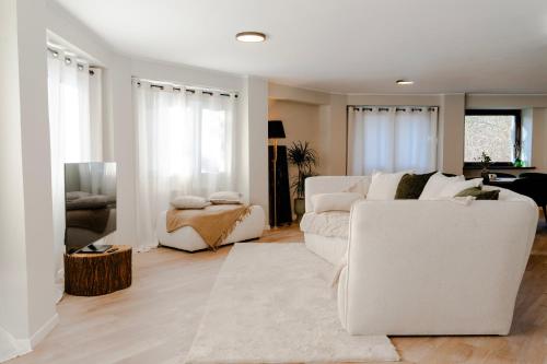 Una sala de estar con un sofá blanco y un televisor. en Villa Octogon Câmpina, en Campina