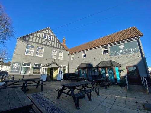 a group of picnic tables in front of a building at The Shurland Hotel in Eastchurch