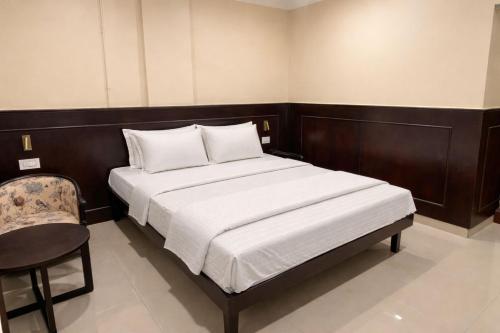 a small bedroom with a bed and a chair at Landmark Inn in Lanka
