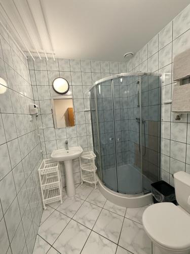 a bathroom with a shower and a sink and a toilet at Pokoje Gościnne Stawiguda in Stawiguda