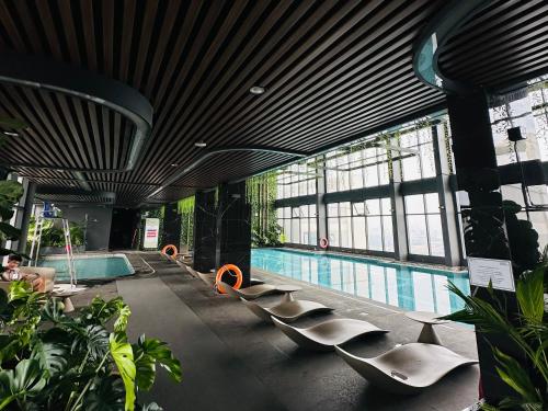 ein Pool mit einer Reihe von Stühlen in einem Gebäude in der Unterkunft Hermes Housing- Masteri West Heights in Hanoi