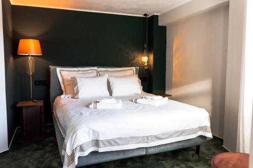 a bedroom with a large white bed with two trays on it at Villa Octogon Câmpina in Campina