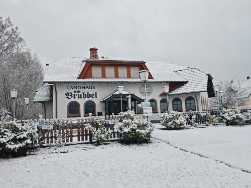 a building with a fence in the snow at Landhaus am Brubbel in Wallenborn