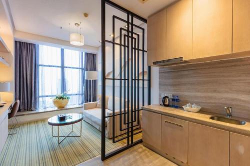 eine Küche und ein Wohnzimmer mit Sofa und Tisch in der Unterkunft Silver Art Hotel in Zhuhai