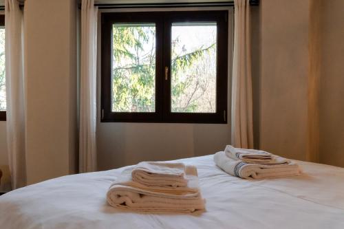 a bed with towels on it with a window at Villa Octogon Câmpina in Campina