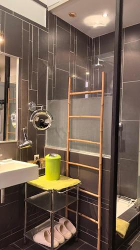 a bathroom with a shower with a yellow stool and a sink at Bartissol et Maillol in Perpignan