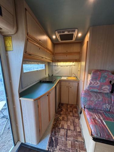 eine Innenansicht eines Wohnmobils mit Küche und Bett in der Unterkunft Palmi Caravan in Poris de Abona