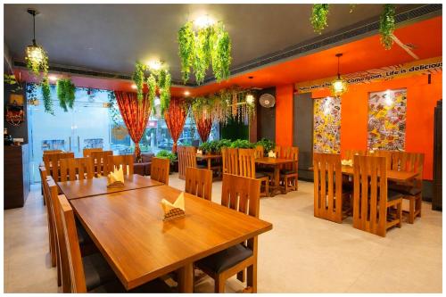 een eetkamer met houten tafels en stoelen bij Hotel A- Grand Residency Near Vishwanath temple - Free Wi-Fi & Restaurants - Air conditioning Room- Best Budget Hotel in Varanasi