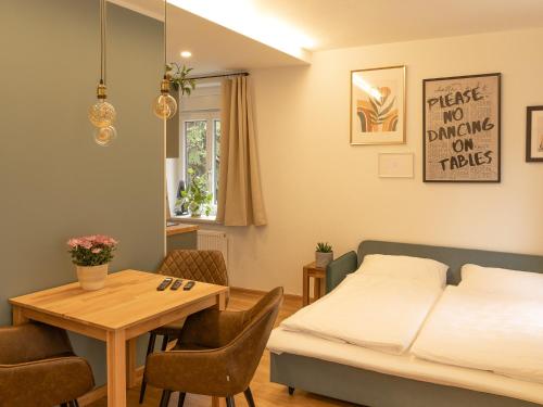 een slaapkamer met een bed en een tafel met stoelen bij Geidorf Residenz - Serviced Apartments & Parking in Graz