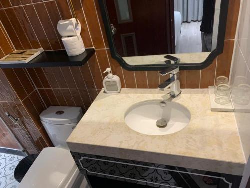 een badkamer met een wastafel en een spiegel bij shen hotel8 in Ho Chi Minh-stad