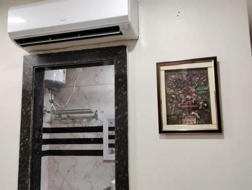 a mirror on a wall next to a painting at Hotel Ravi Residency in Jalandhar