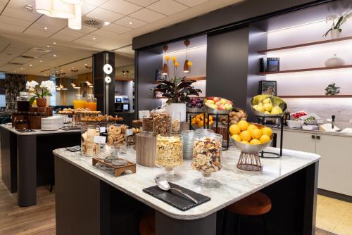 Una línea de buffet con frutas y otros postres en un mostrador. en Crowne Plaza Padova by IHG, en Padua