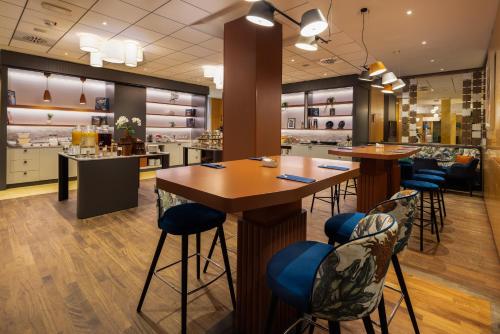 Un restaurante con una mesa y sillas y un bar. en Crowne Plaza Padova by IHG, en Padua