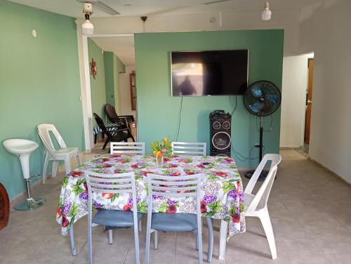 una sala da pranzo con un tavolo con sedie e una televisione di Casa tinajas a Santiago del Estero