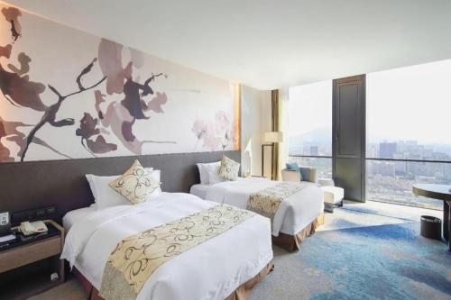 LONGYAN JINGHUA FLIPORT HOTEL في لونغيان: غرفة فندقية بسريرين ونافذة كبيرة