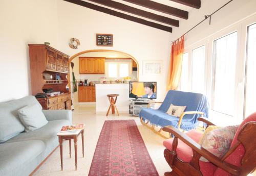 een woonkamer met een bank en een tv bij Calypso in Jávea