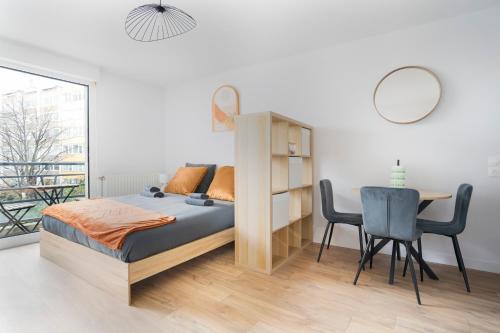 a bedroom with a bed and a table and chairs at Le Cocon Lyonnais in Lyon