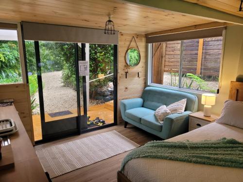 een kamer met een bed, een bank en een raam bij Forest view bungalow in Nambucca Heads
