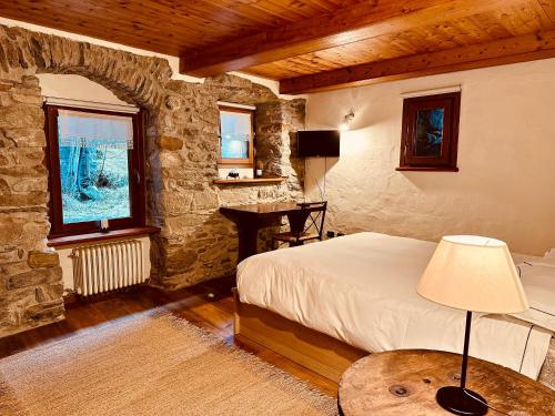 a bedroom with a bed and a desk in a room at Maison Bovet Mont Blanc in La Salle