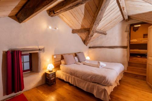 ein Schlafzimmer mit einem Bett in einem Zimmer mit Holzdecken in der Unterkunft L'Oustal du Larzac, gîte en Aveyron in La Bastide-Pradines