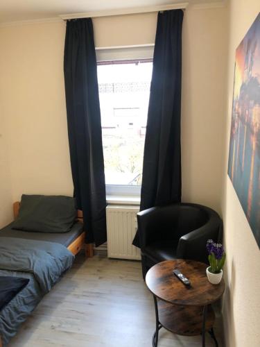 ein Schlafzimmer mit einem Bett, einem Stuhl und einem Tisch in der Unterkunft Pension Karsten Mertens in Gardelegen