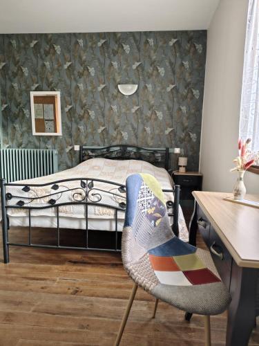 a bedroom with a bed and a desk and a chair at Le Relais de Boralde in Espalion