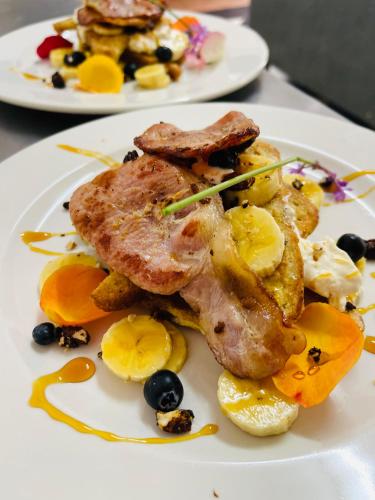 zwei Teller mit Lebensmitteln auf einer weißen Platte in der Unterkunft Die Ou Pastorie in Hartbeespoort