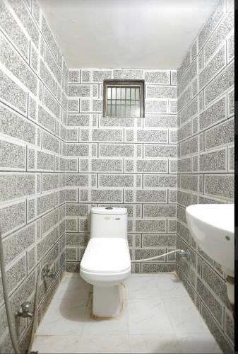 a bathroom with a white toilet and a sink at Hotel Shree Rameshwaram Near by All Temple in Ayodhya