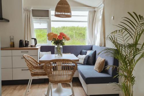 een woonkamer met een blauwe bank en een tafel bij The Pelican in Schoorldam