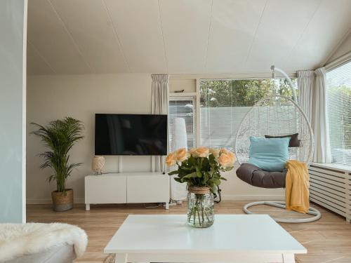 een woonkamer met een vaas met bloemen op een tafel bij The Pelican in Schoorldam