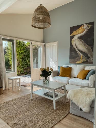 a living room with a couch and a table at The Pelican in Warmenhuizen