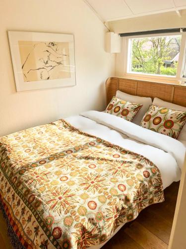 a bedroom with two beds and a window at Strandbries in Warmenhuizen