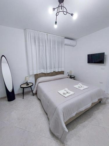 a bedroom with a bed and a window and a mirror at Dimora del Centro in Marsala
